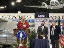 ARRL has honored Phil Karn, KA9Q, with the Mary Hobart, K1MMH, Medal of Distinction. Karn is seen speaking to the crowd. ARRL Director of Development, Kevin Beal, K8EAL, and ARRL CEO David Minster, NA2AA, look on. [Bob Inderbitzen, NQ1R, photo]